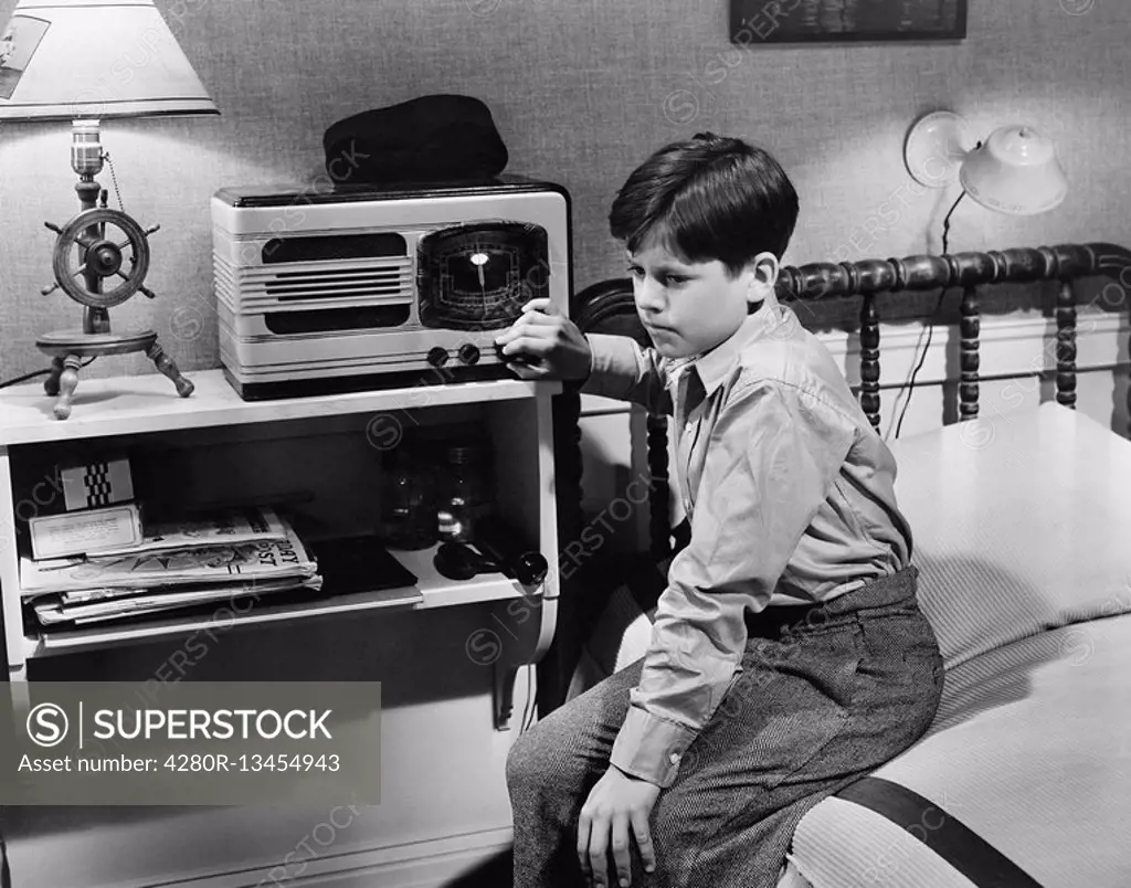 Boy listening to radio in bedroom All persons depicted are not longer living and no estate exists Supplier warranties that there will be no model rele...