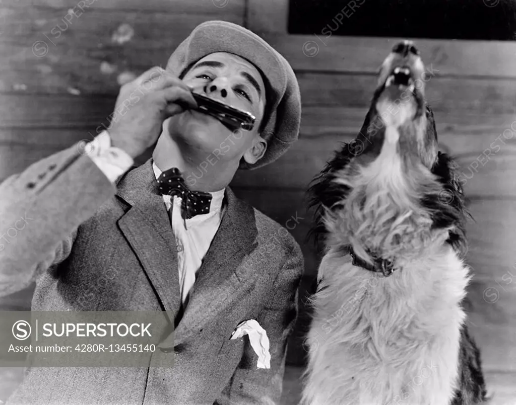 Man playing harmonica with howling dog All persons depicted are not longer living and no estate exists Supplier warranties that there will be no model...