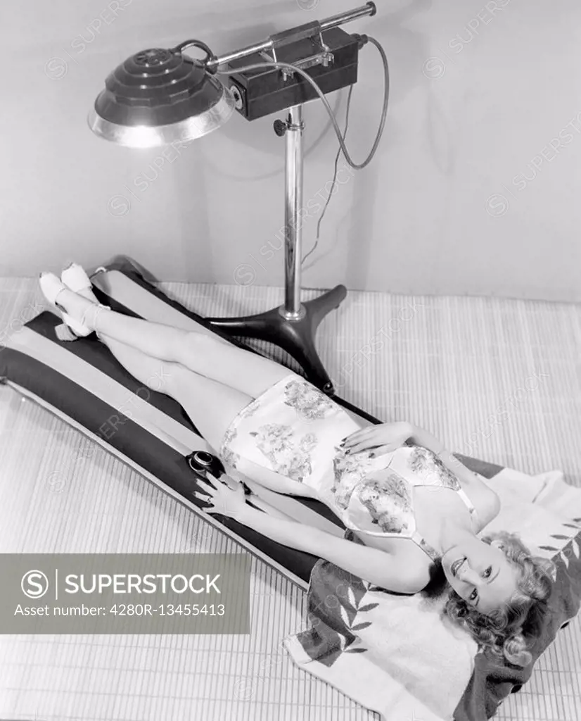 Portrait of woman under tanning lamp All persons depicted are not longer living and no estate exists Supplier warranties that there will be no model r...