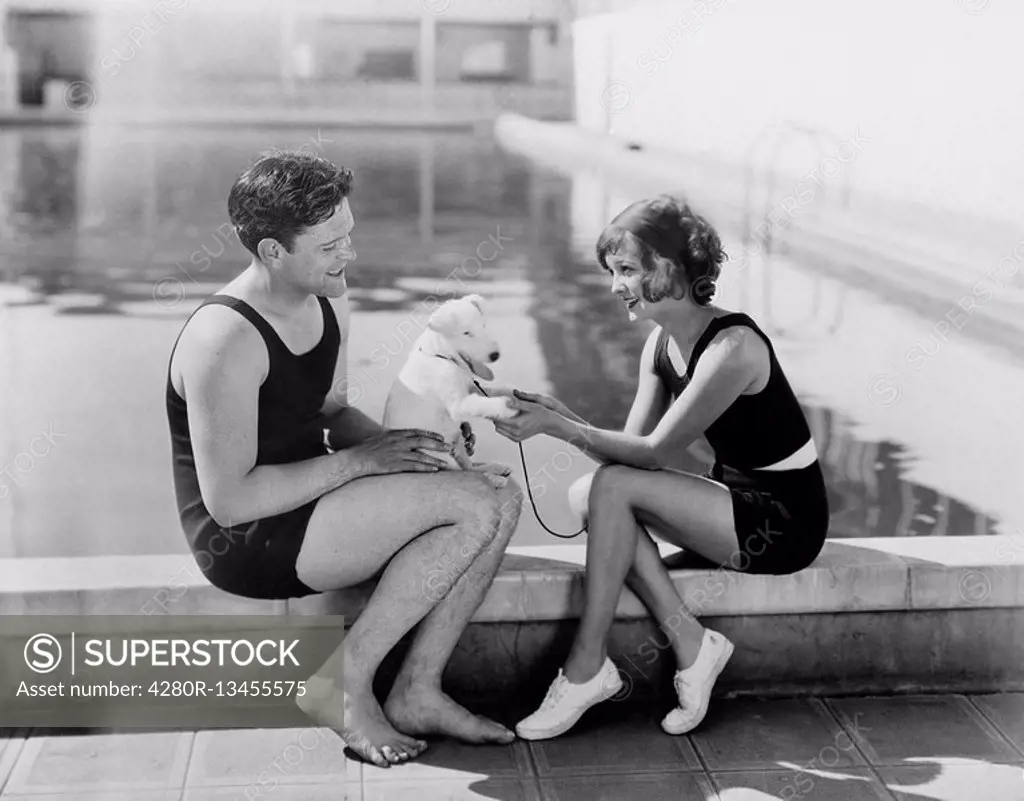 Couple sitting with their puppy next to a pool All persons depicted are not longer living and no estate exists Supplier warranties that there will be ...