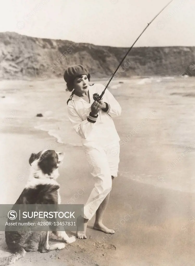 Fishing at the beach with her dog (OLVI007_OU826_F)