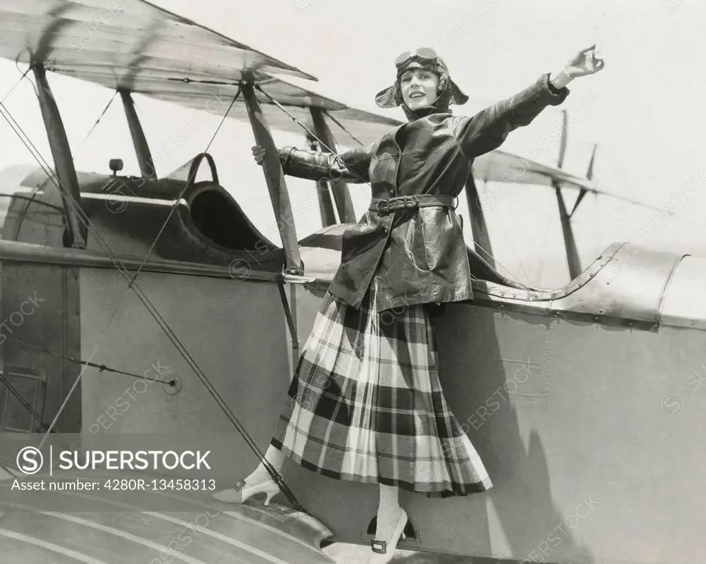 Aviatrix standing on bi-plane (OLVI008_OU309_F)