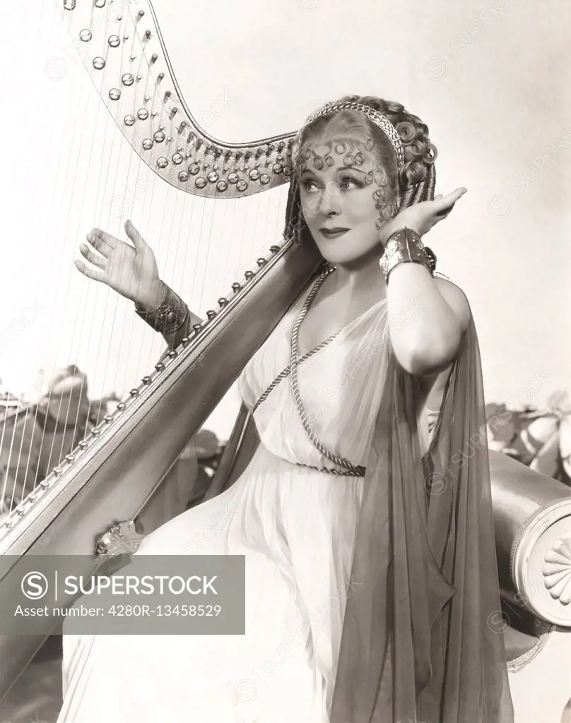 Woman in ancient Greek costume playing harp