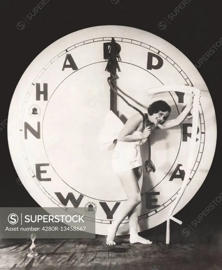 Woman pulling the hour hand of giant clock on New Year's Eve