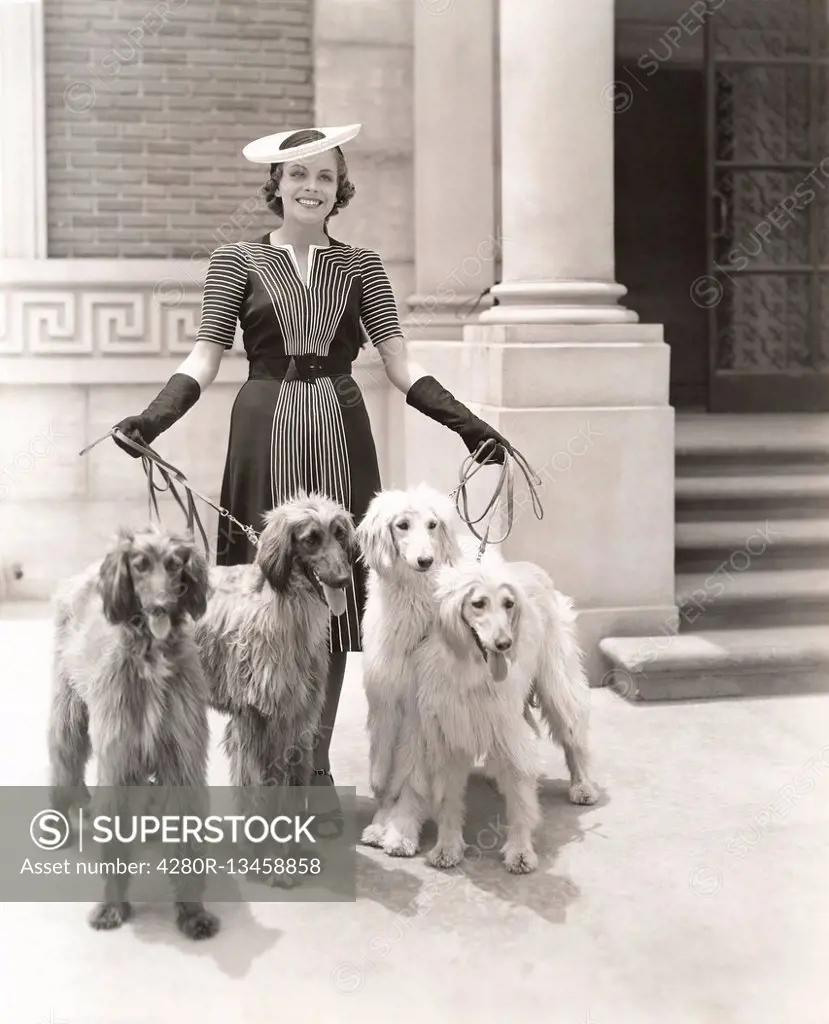 A woman and her four Afghan Hounds