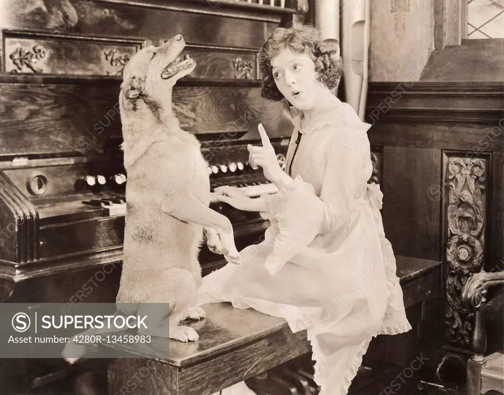 Dog accompanying woman on piano