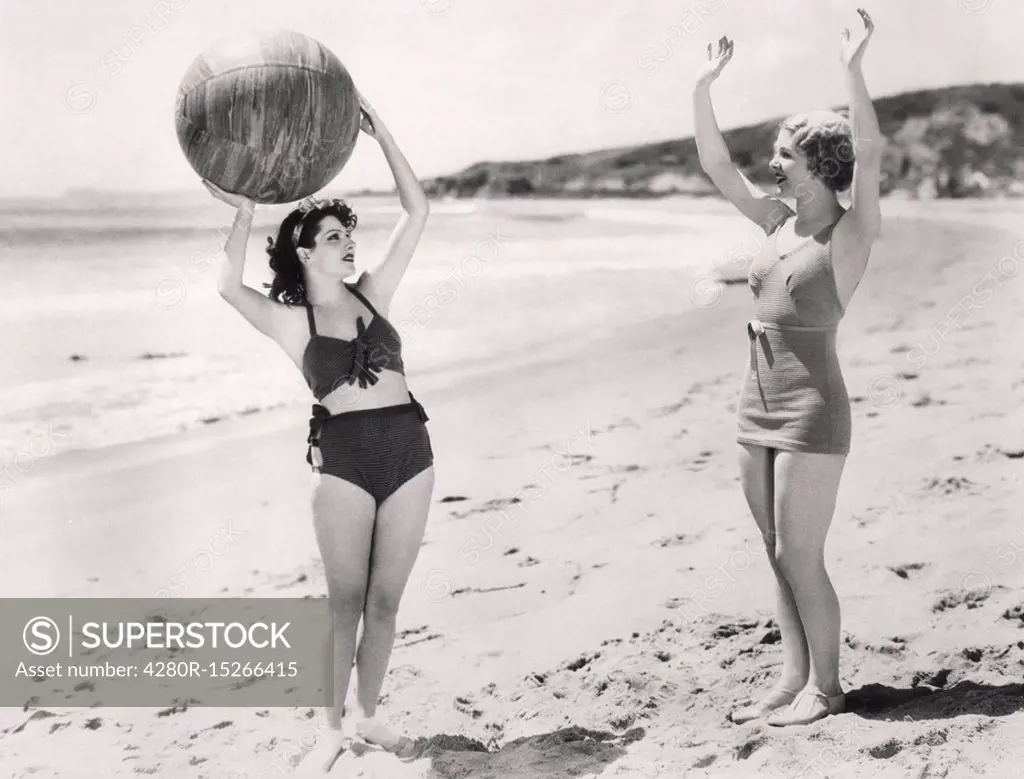 Two women playing ball on the beach