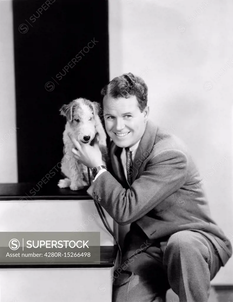 Man posing with his wire haired terrier