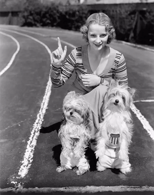 Woman with her two dogs on a race track All persons depicted are not longer living and no estate exists Supplier warranties that there will be no mode...