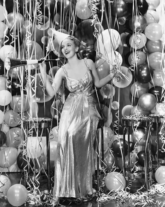 Woman celebrating with room full of balloons All persons depicted are not longer living and no estate exists Supplier warranties that there will be no...