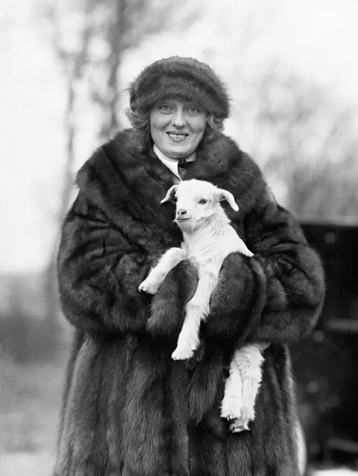 Woman in a fur coat and hat holding a small baby lamb in her arms All persons depicted are not longer living and no estate exists Supplier warranties ...