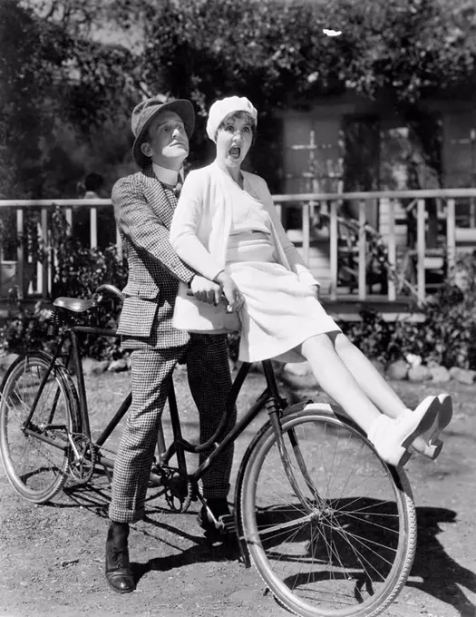 Couple sitting on a tandem bicycle All persons depicted are not longer living and no estate exists Supplier warranties that there will be no model rel...