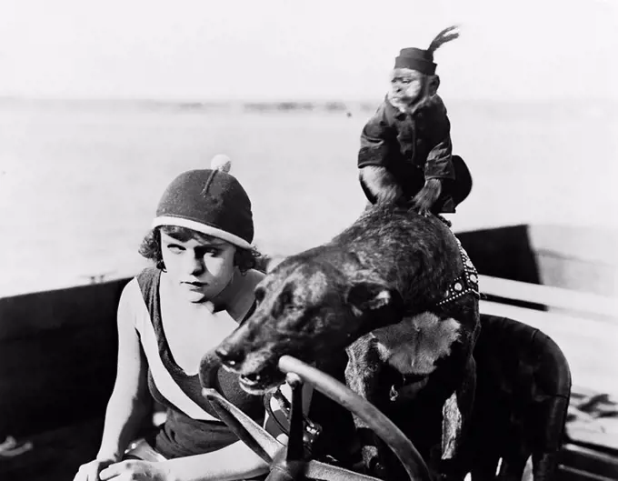 Teenage girl sitting in a motorboat driven by a dog All persons depicted are not longer living and no estate exists Supplier warranties that there wil...