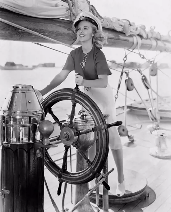 Portrait of woman steering boat All persons depicted are not longer living and no estate exists Supplier warranties that there will be no model releas...