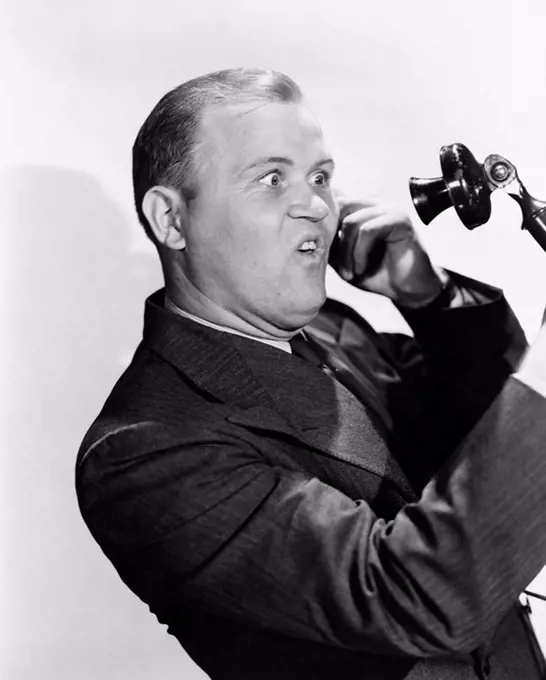 Man with funny expression using telephone All persons depicted are not longer living and no estate exists Supplier warranties that there will be no mo...