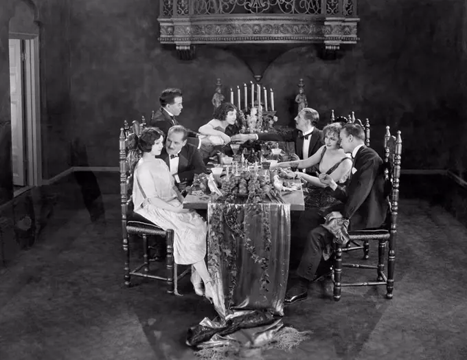 Group of people having dinner party All persons depicted are not longer living and no estate exists Supplier warranties that there will be no model re...