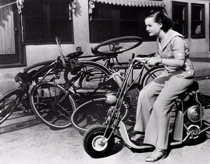 Leaving bicycles in the dust, a young woman fancies a miniature motorbike All persons depicted are not longer living and no estate exists Supplier war...