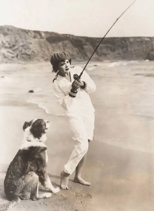 Fishing at the beach with her dog (OLVI007_OU826_F)