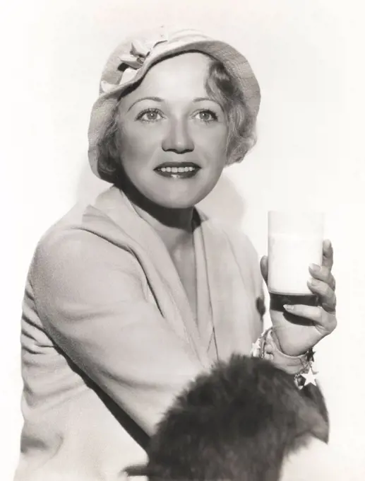 Woman in hat holding a glass of milk