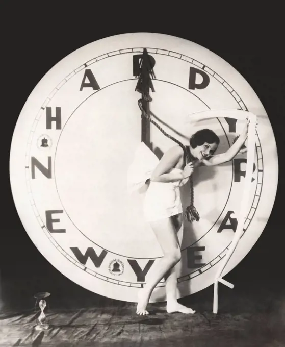 Woman pulling the hour hand of giant clock on New Year's Eve