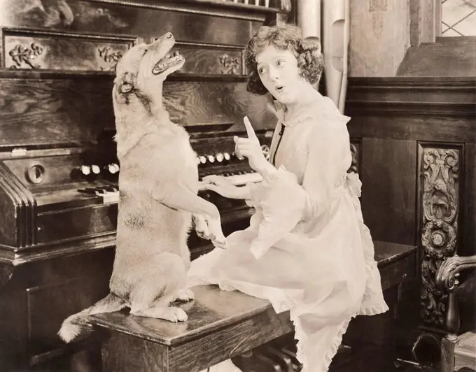 Dog accompanying woman on piano