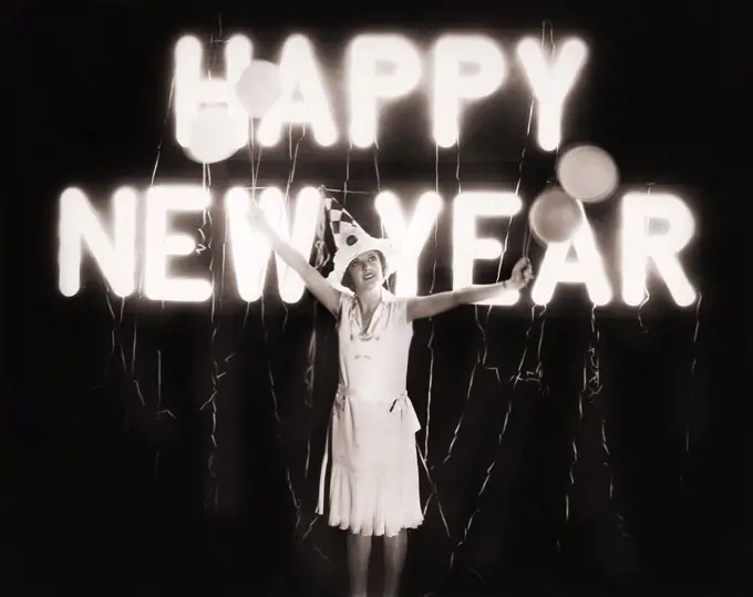 Woman standing in front of neon Happy New Year sign