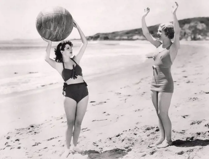 Two women playing ball on the beach