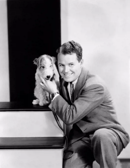 Man posing with his wire haired terrier