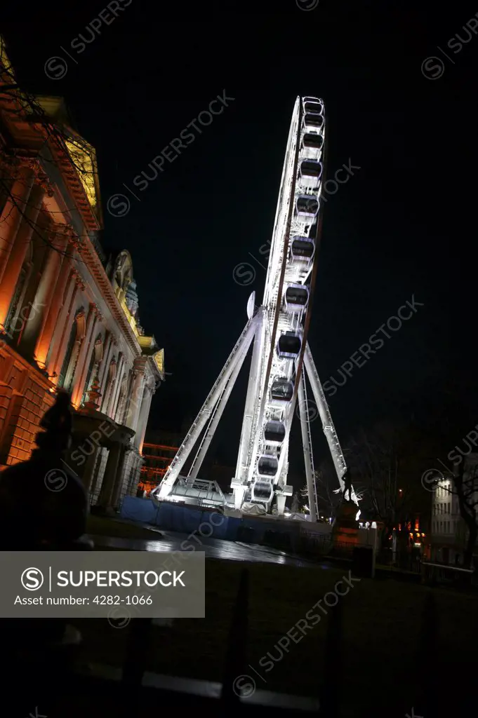 Northern Ireland, Belfast, Donegall Square. Exterior view of Belfast City Hall and the Belfast Wheel illuminated at night.