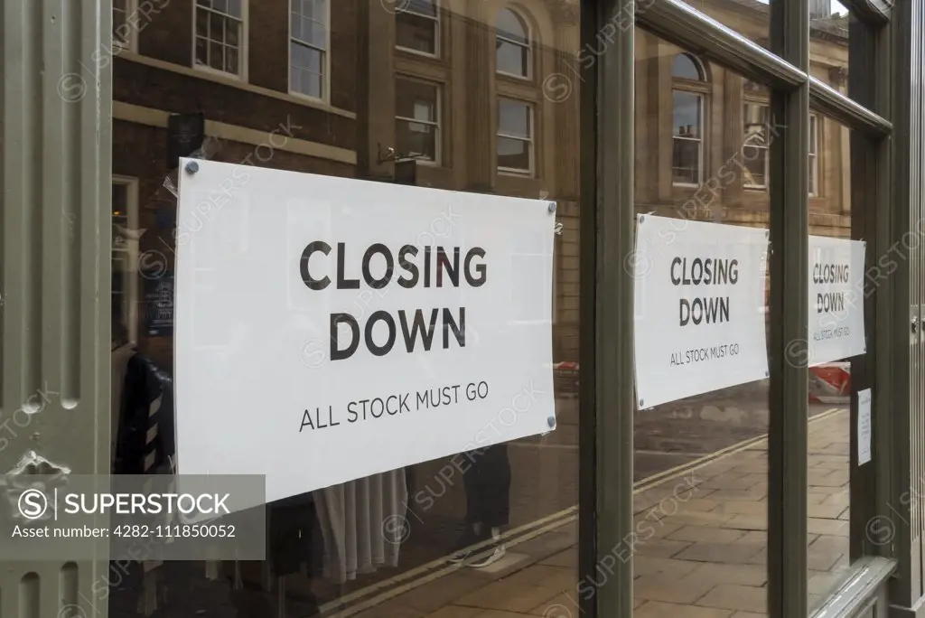 Closing down sign on shop store window. SuperStock