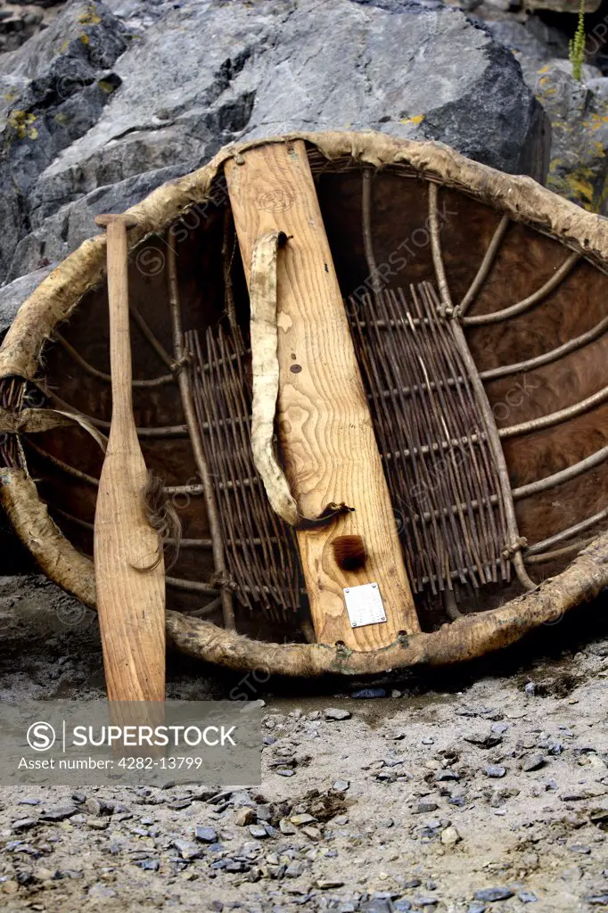 Scotland, Banffshire, Portsoy. A traditional coracle boat and paddle.