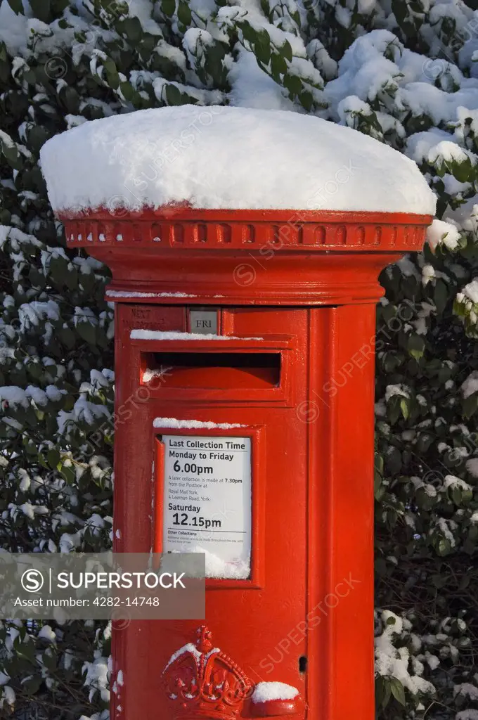 England, North Yorkshire, York. Traditional red post box in winter.