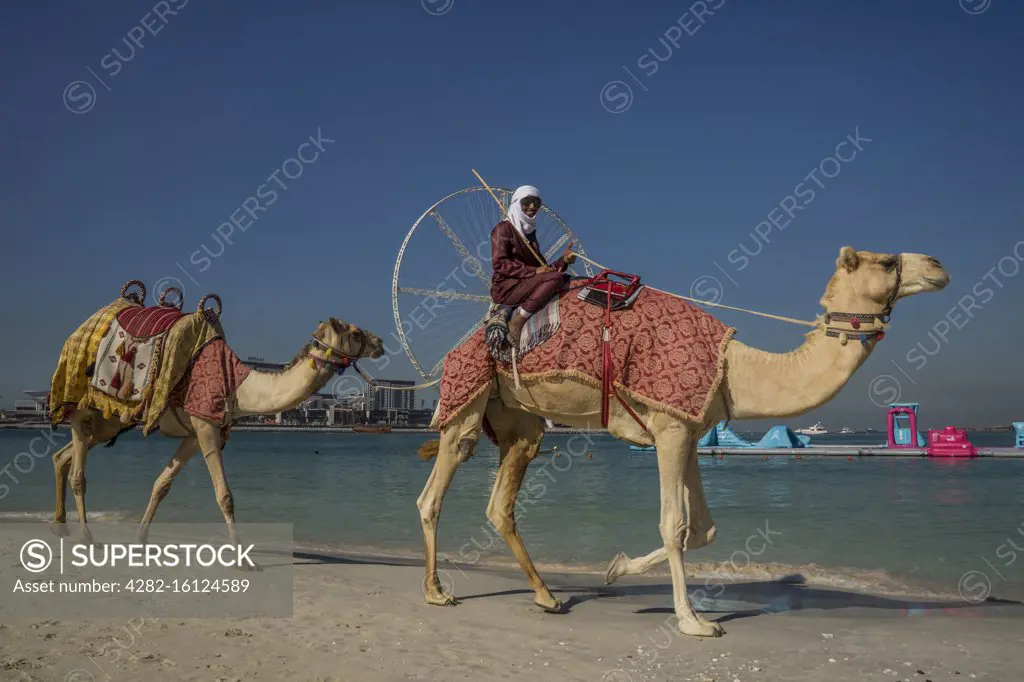 A Bedouin man smiles as he passes in front of Ain Dubai which is the world's largest ferris wheel on Jumeirah Beach in Dubai.