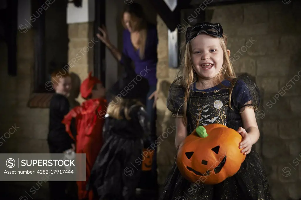 Halloween Party With Children Trick Or Treating In Costume