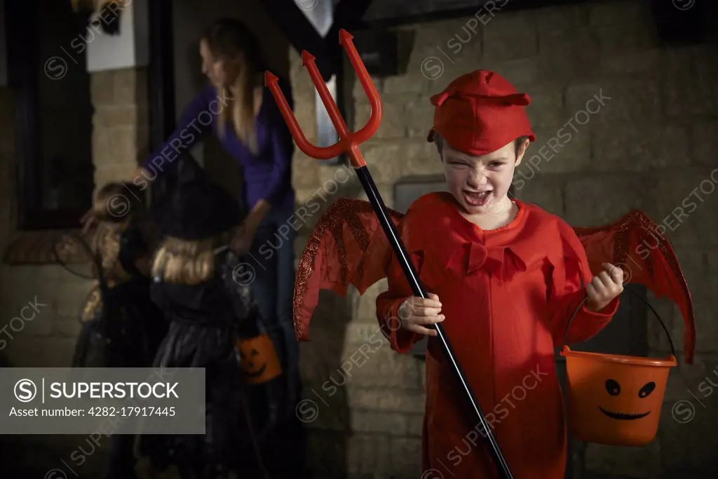 Halloween Party With Children Trick Or Treating In Costume