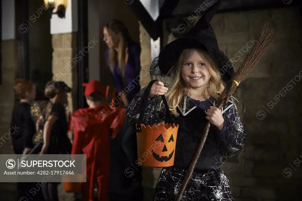 Halloween Party With Children Trick Or Treating In Costume