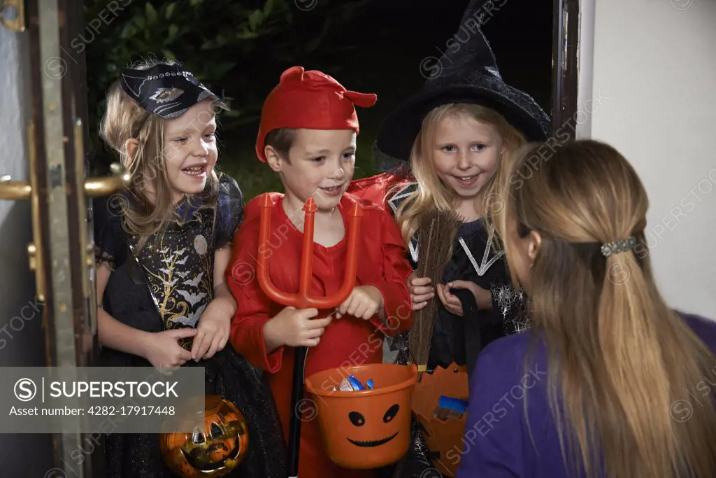 Halloween Party With Children Trick Or Treating In Costume