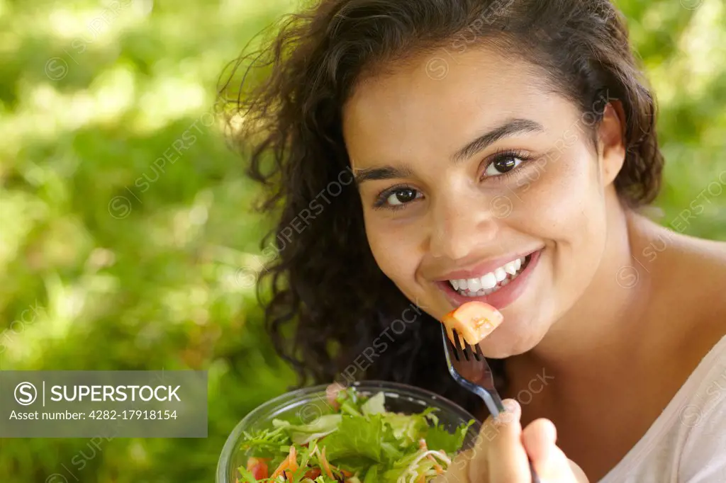 Young Woman Eating Healthy Salad Outdoors