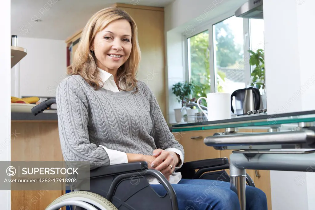 Portrait Of Mature Disabled Woman In Wheelchair At Home