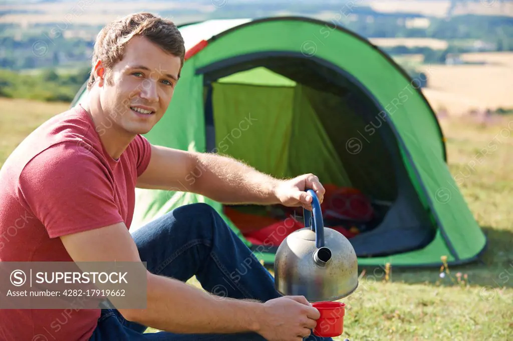 Young Man Camping In Countryside