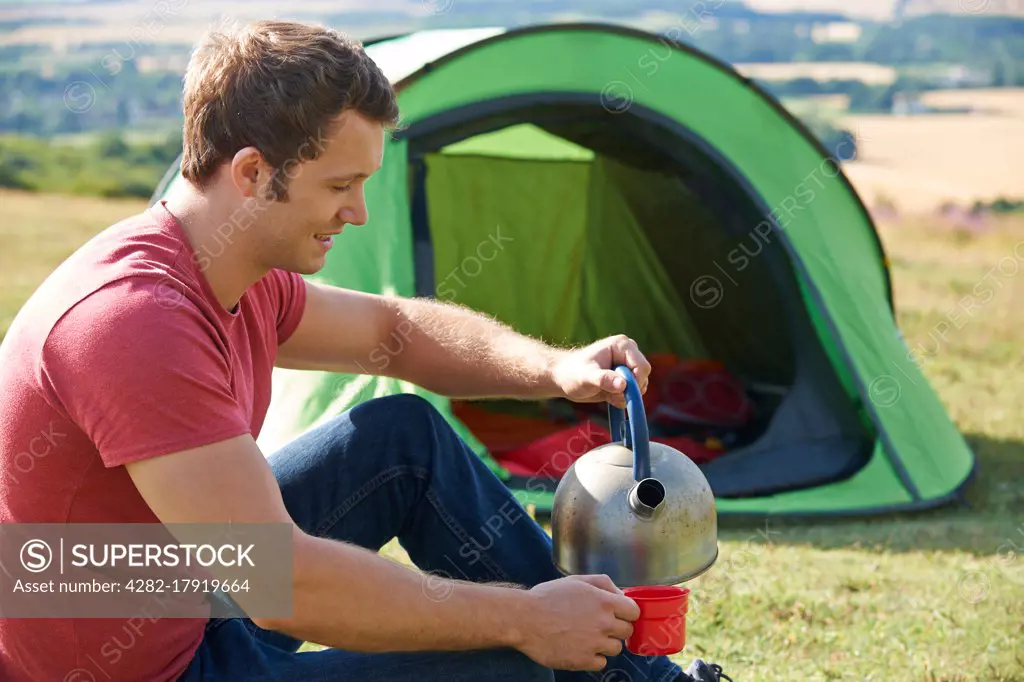 Young Man Camping In The Countryside