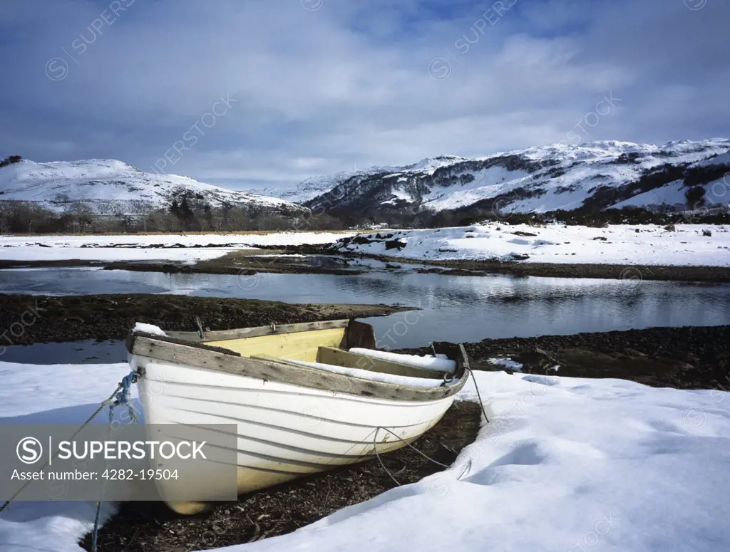 Scotland, Highland, Glenelg. Boat by the Glenmore river estuary in Galltair, with snow on the ground in late winter.