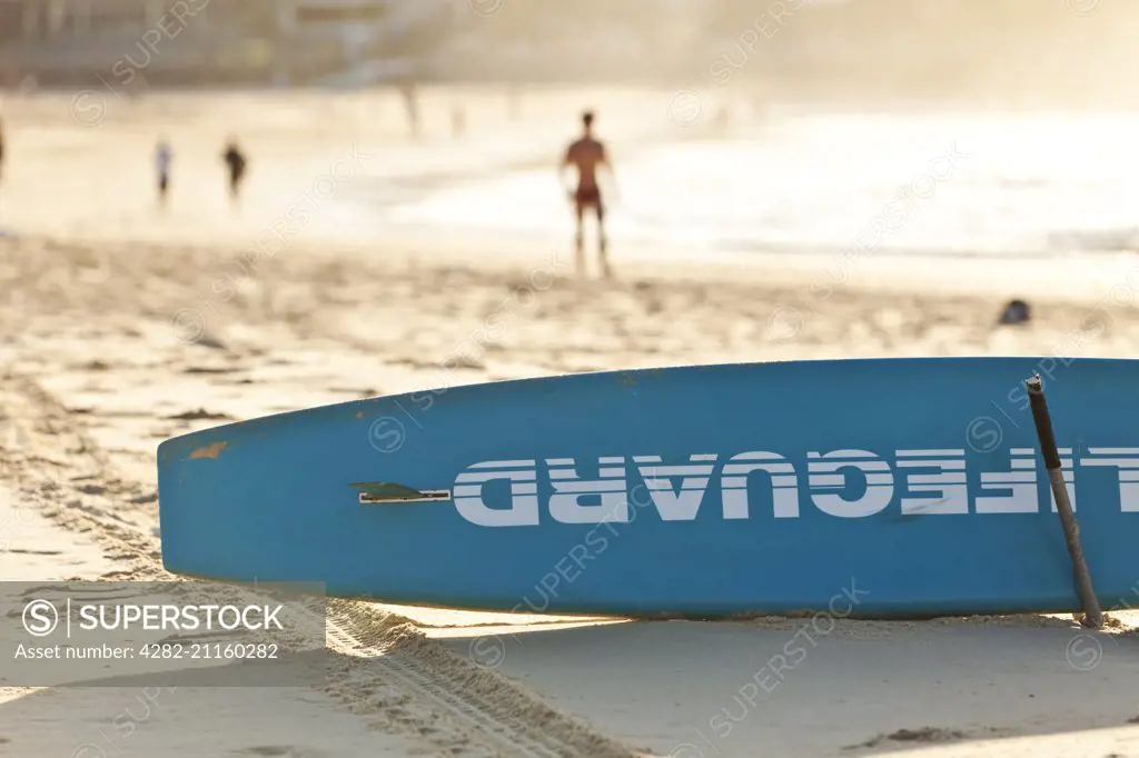 A view of a lifegurad's surf board on Bondi beach at dawn.