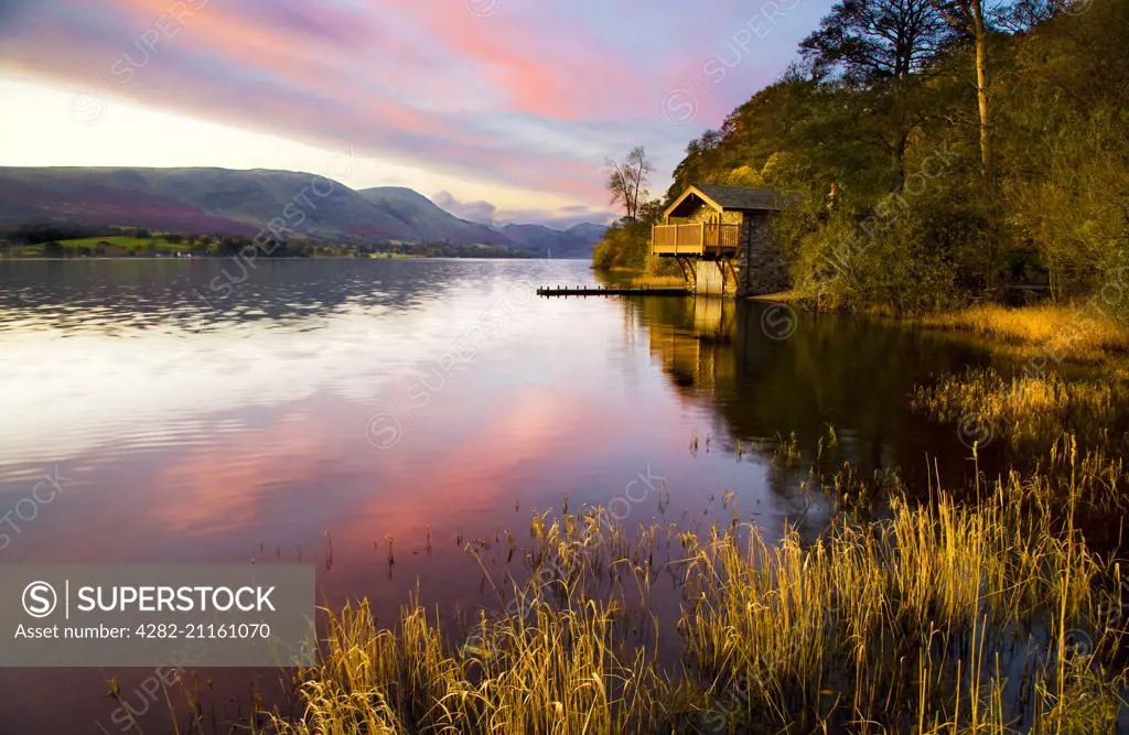 Early morning light falls on a boathouse near Pooley Bridge on the shores of Ullswater.