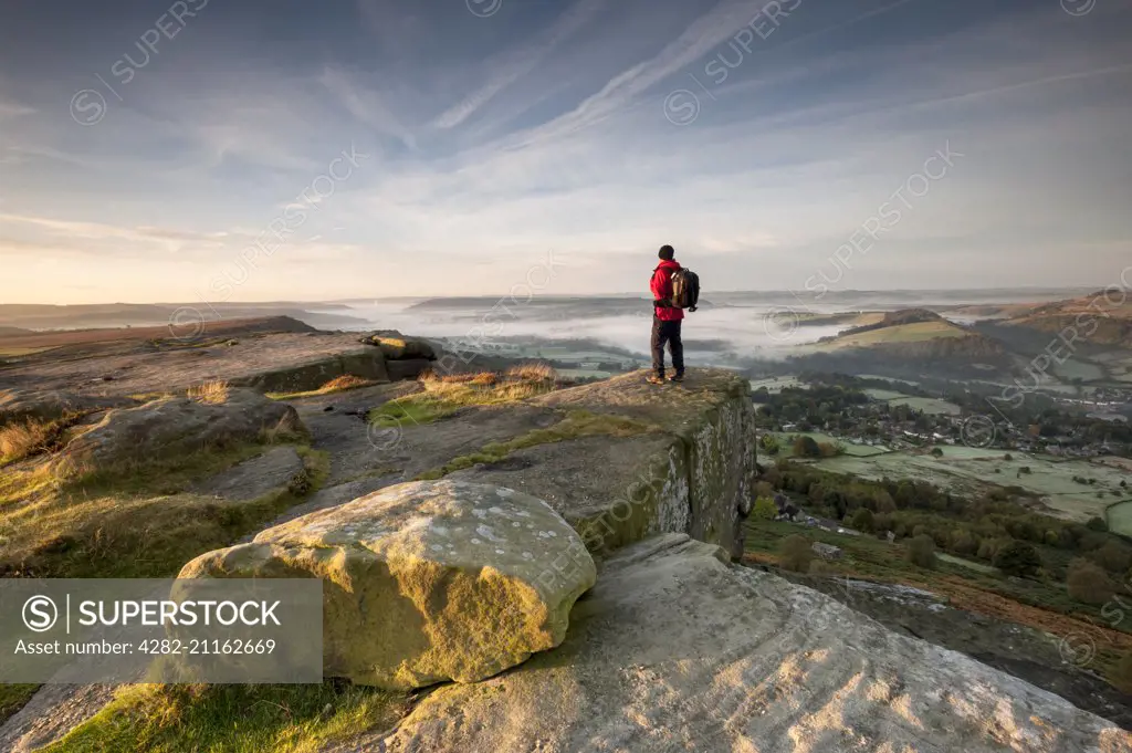 A walker looking across the valley at Curbar Edge.