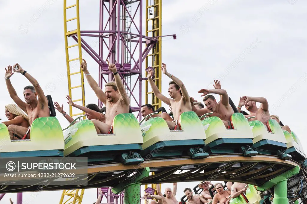 Naked thrill seekers ride the Green Scream roller coaster on a