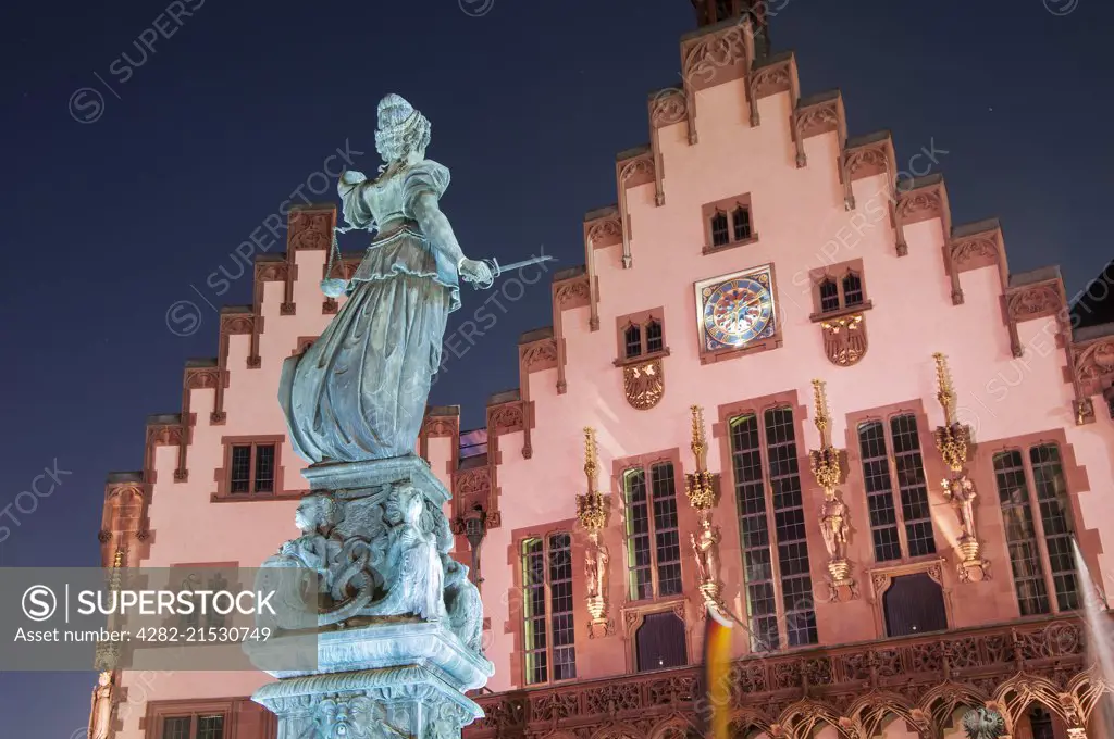 The Justice Fountain or Lady Justice in front of the Town Hall at night in The Romer.