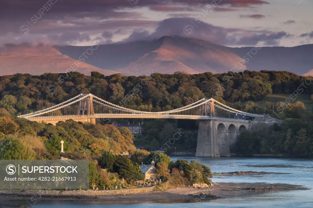 Menai Bridge over the Menai Strait backed by the mountains of Snowdonia in North Wales.