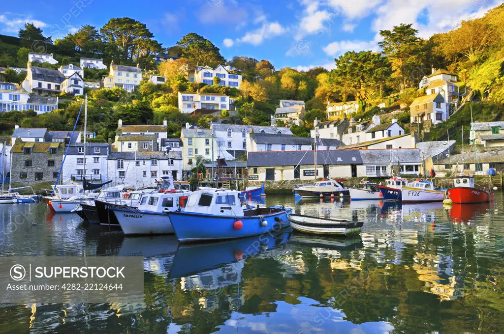 The pretty fishing village of Polperro showing the inner harbour with its colourful fishing boats and traditional cottages.