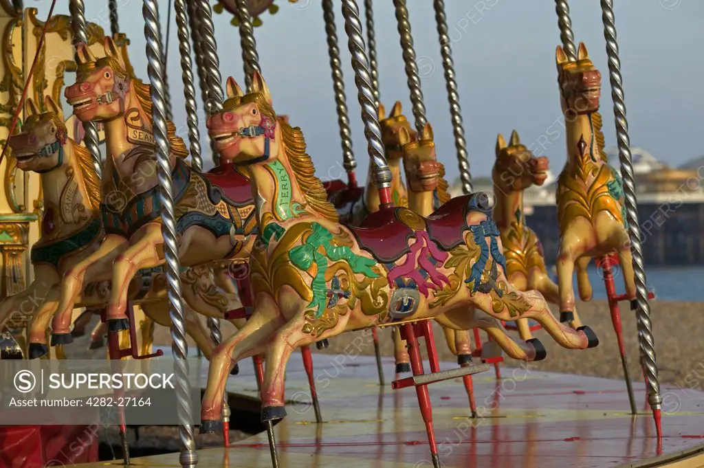 England, East Sussex, Brighton. Detail of Painted Horses on a Merry-Go-Round. This amusement ride, also called a carousel, consists of a rotating platform with seats for passengers in the form of wooden horses or animals.
